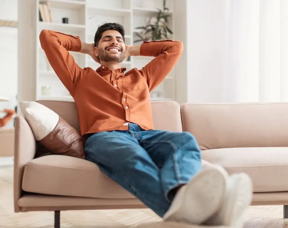 homem sorridente descansando no sofá