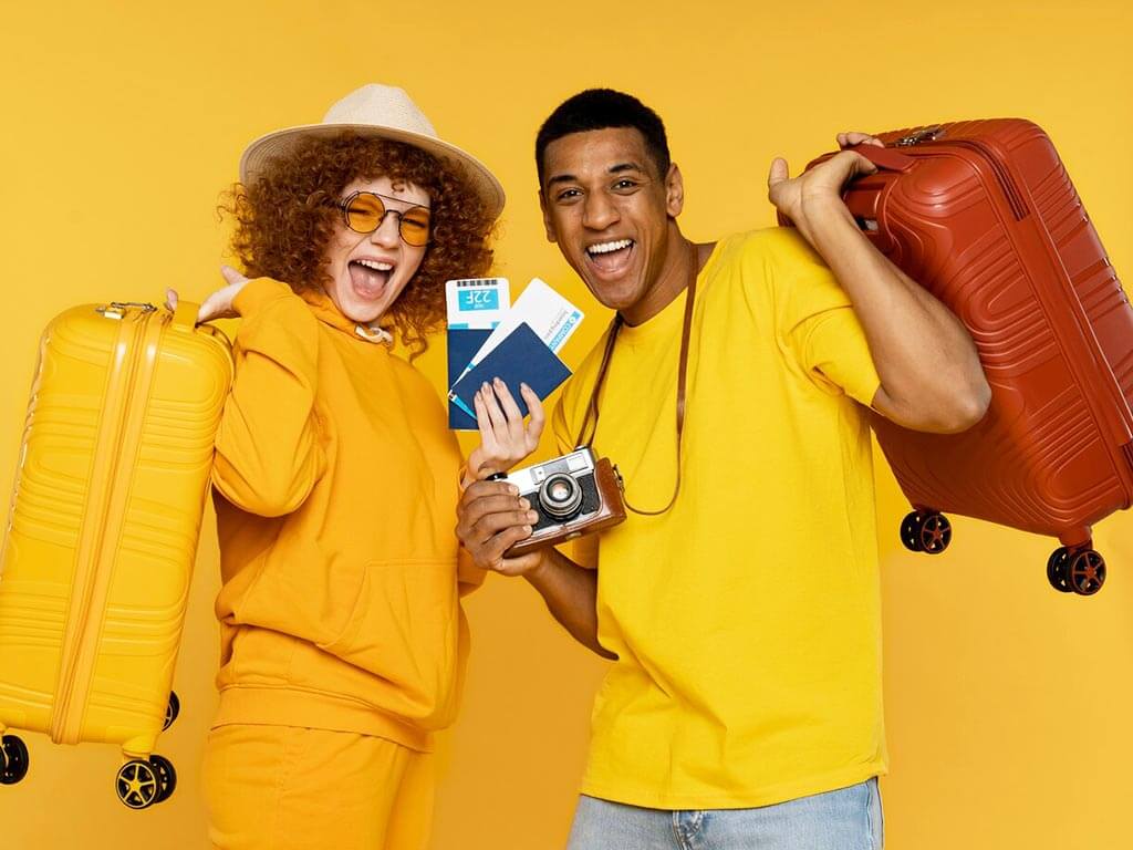 fundo-amarelo-e-casal-de-jovens-segurando-malas-passaportes-e-maquina-fotografica-retro